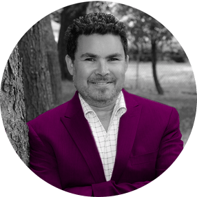 Black and White Photo of Jason Kramer Standing Beside a Tree Wearing Purple Suit